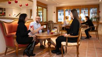 Three people in the Keramikcafé in Liechtenstein with coffee and tea in a cozy lounge atmosphere.
