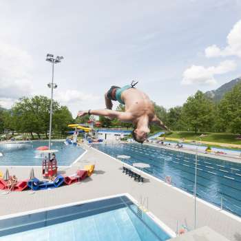 unge somersaults from the 1-meter board into the pool at Mühleholz swimming pool - pure summer fun.