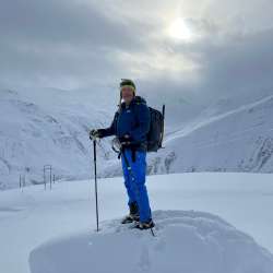 Snowshoe hike with hiking guide Nikolaus Büchel Nikolaus Büchel stands with rucksack and poles during a snowshoe hike in a wintry high mountain landscape