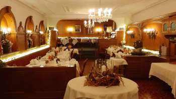 Elongated hall with festively laid tables, elegant decorations and warm lighting Elongated hall with festively laid tables, elegant decorations and warm lighting