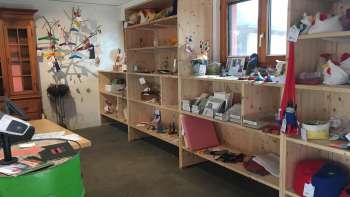 Interior of the Birkahoflädile with wooden shelves full of regional products, decoratively designed with colorful elements - farm store in Liechtenstein.