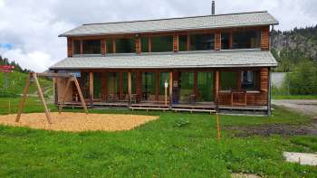 Exterior shot of the Malbipark-Bistro with a playground and meadow in the foreground