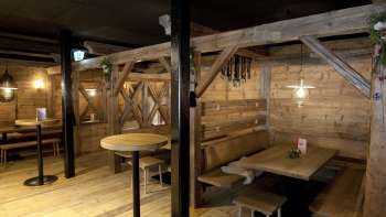 Cozy seating area with wooden benches and tables in the traditional Malbuner Lädeli style