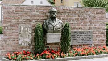 Rheinberger monument in Vaduz with red flowers underneath
