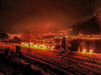 Spectators watch the sparkling spectacle at night with a view of the illuminated Rhine Valley