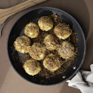 Freshly fried plum dumplings in butter crumbs - Liechtenstein pastry served in a pan