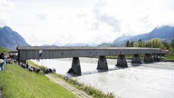 The historic Old Rhine Bridge between Vaduz and Sevelen - covered wooden bridge over the Rhine with a panoramic view of the Alps.