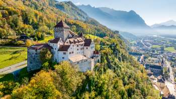 Vaduz Castle against an autumnal Alpine backdrop with a view over the Rhine Valley