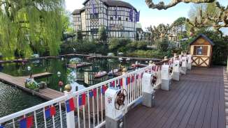 Remote control boats in the Europa-Park water basin, surrounded by half-timbered houses and spring trees
