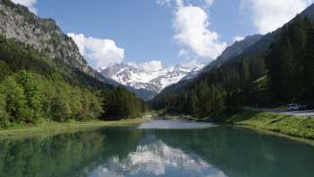 View of the Gänglesee lake in Steg with mountains in the background