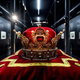 Close-up of the Princely Crown of Liechtenstein on a red velvet cushion with gold embroidery, on display in the Liechtenstein TreasureChamber