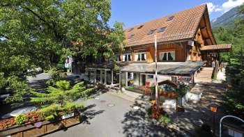Exterior view of the main building of the Mittagsspitze campsite with restaurant and shady terrace.