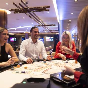 Friendly atmosphere at the gaming table: three guests chat with the croupière in the stylishly furnished Casino Schaanwald.