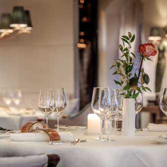 White table setting with candle, rose and wine glasses in the elegant restaurant of the Park Hotel Sonnenhof in Vaduz, Liechtenstein