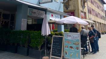 Exterior view of Elisas restaurant with parasols and menu on the blackboard