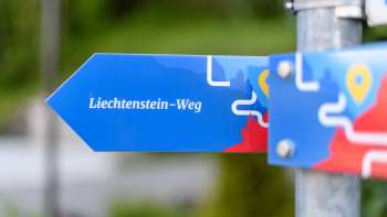 Blue signpost with the inscription "Liechtenstein Trail" in a modern design.