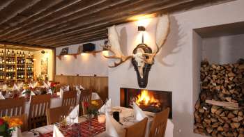 Cozy restaurant ambience with rustic wooden beams and fireplace