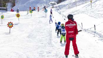 A ski instructor and children on the chairlift at Malbi Park