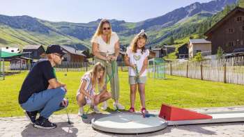 Family playing minigolf on the Alpine Minigolf in Malbun