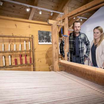Visitors look at the loom in the Walser Museum