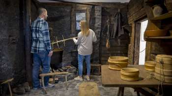 Visitors explore an old smoke kitchen in the Walser Museum Triesenberg