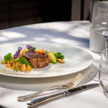Exquisite main course with succulent meat, fresh vegetables and decorative flowers