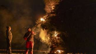 Two men light a large bonfire during the night at the traditional Spark Sunday in Liechtenstein.