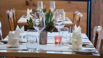 Close-up of a beautifully laid table with glasses, cutlery and small plant decorations