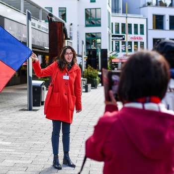 City guide with Liechtenstein flag welcomes tourist group in Vaduz