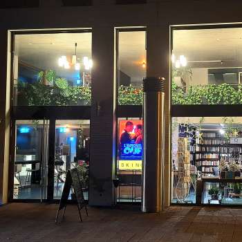 Illuminated exterior view of the Skino cinema in Schaan at night, with large glass fronts and an inviting atmosphere.