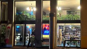 Illuminated exterior view of the Skino cinema in Schaan at night, with large glass fronts and an inviting atmosphere.