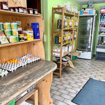  Interior view of the Aeulehof farm store with shelves full of regional products, including eggs and preserves.