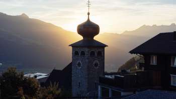 Onion dome of St. Joseph's parish church with the setting sun in the background