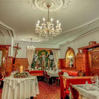 Close-up of a chandelier above festively laid tables in a rustic ambience