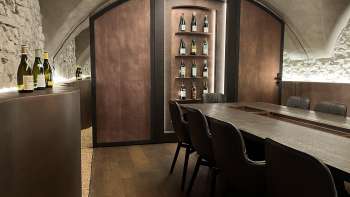 Elegant tasting room of the WY Weinbar with vaulted ceiling and elegant wooden table for exclusive wine tastings.