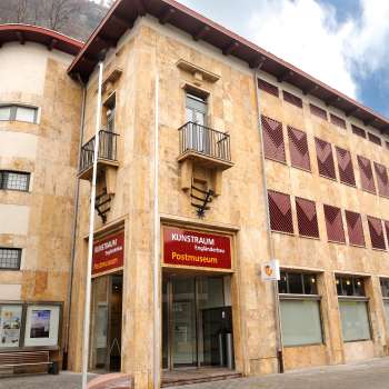 Exterior view of the PostMuseum with its striking natural stone façade and red shutters in the center of Vaduz.