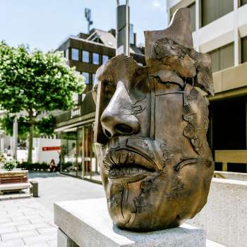A modern bronze sculpture of a face in the old town of Vaduz