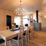 Light wooden interior with dining table and fireplace at Haus Ochsenkopf in Malbun, Liechtenstein