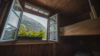 Window view from the dormitory: View of the mountain landscape from a simple dormitory with bunk beds at the Gafadura hut