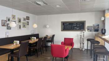  Cozy café with modern seating, decorative picture wall and warm wooden floor