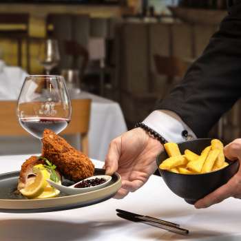 Served dish with breaded meat and French fries in a modern presentation in the Alpspitz restaurant.