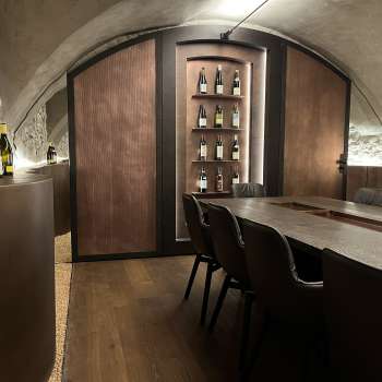 Elegant tasting room of the WY Weinbar with vaulted ceiling and elegant wooden table for exclusive wine tastings.