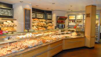 View of the sales room of the Amann bakery and confectionery with a full counter and lots of treats