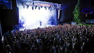 Large crowd in front of illuminated stage at the Vaduz Soundz 2024 open-air concert in Liechtenstein