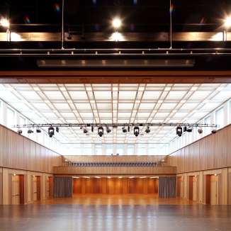 Large event hall with wooden paneling, stage and lighting in Schaan, Liechtenstein - suitable for events, conferences and concerts
