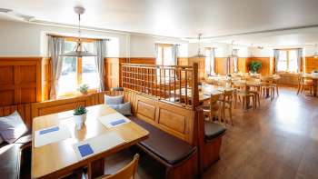 A bright, traditional-style dining room with wood paneling at Restaurant Rössle