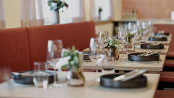 Close-up of stylishly laid tables in the RUUF restaurant with dark crockery and flower vases
