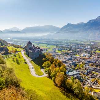 Aerial view of Vaduz Castle with a view over the city of Vaduz and the Rhine Valley on a clear fall day