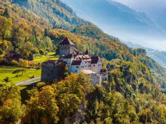 Vaduz Castle on a wooded hill in an autumnal landscape in Liechtenstein