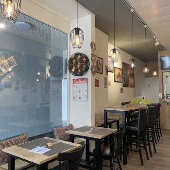 Stylishly furnished dining room with black wooden furniture, wooden floors and creative wall decorations